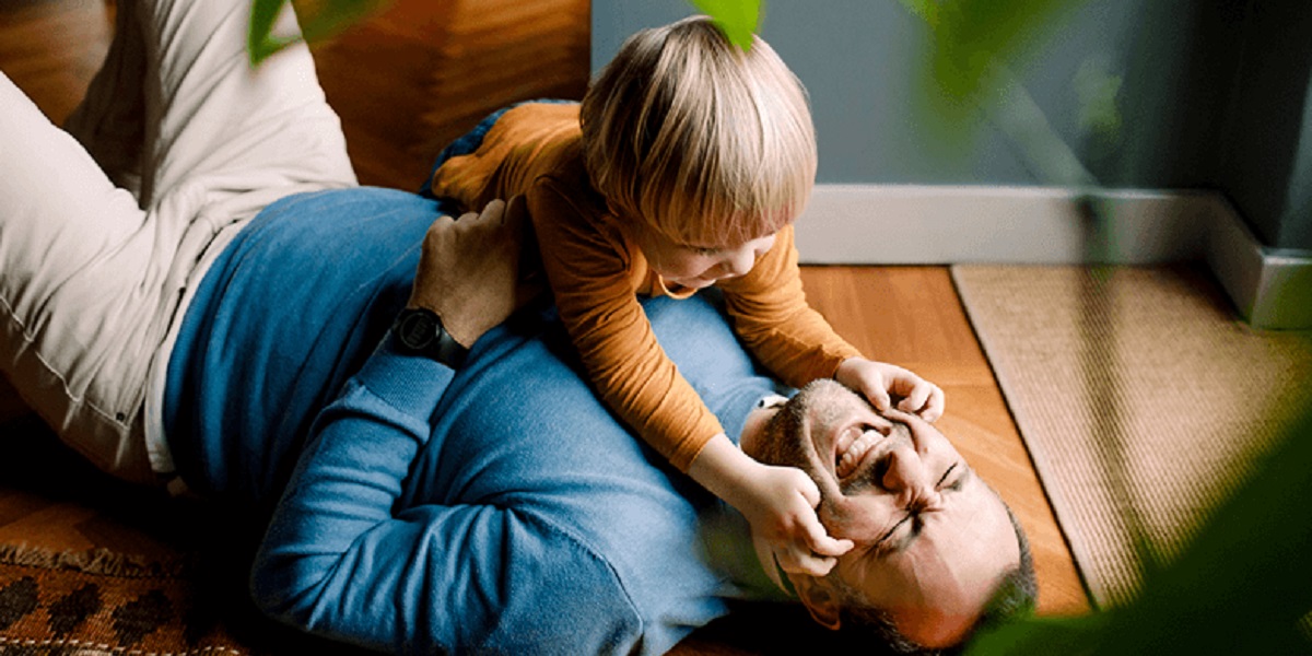 A father and son playing on the floor.