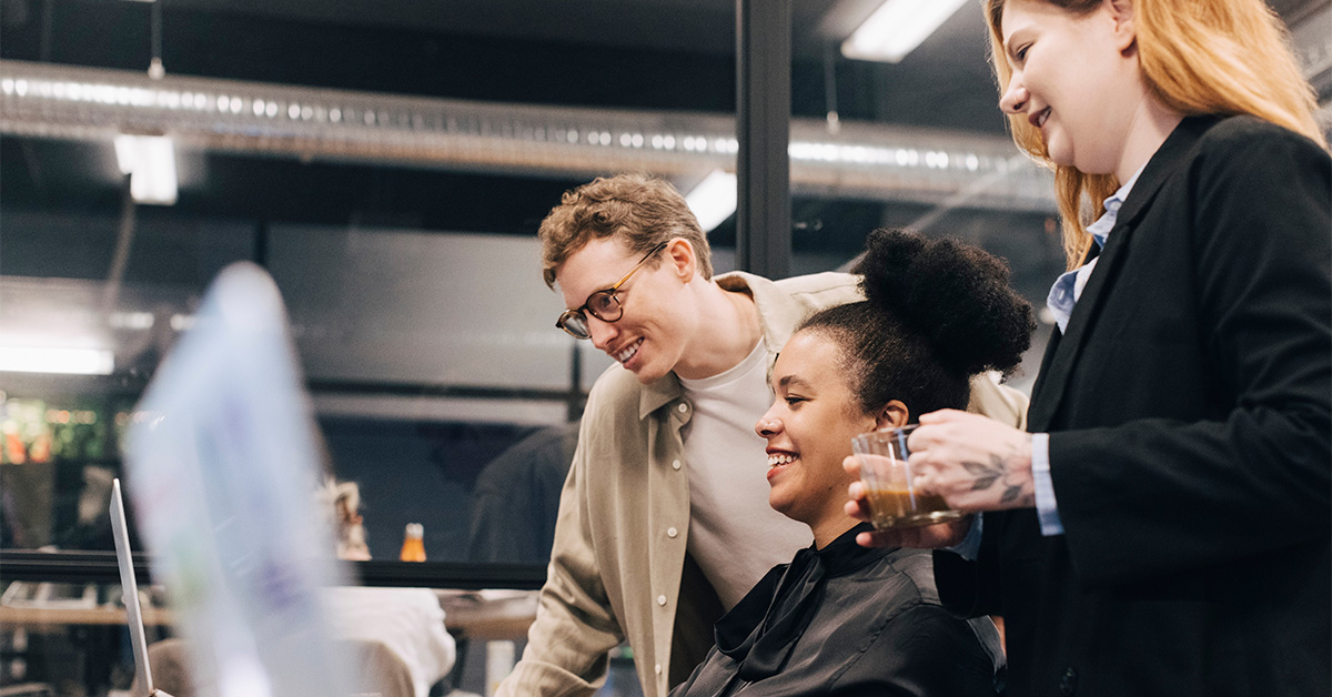 Three employees looking at a computer screen